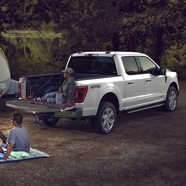 Truck at campsite with two people relaxing
