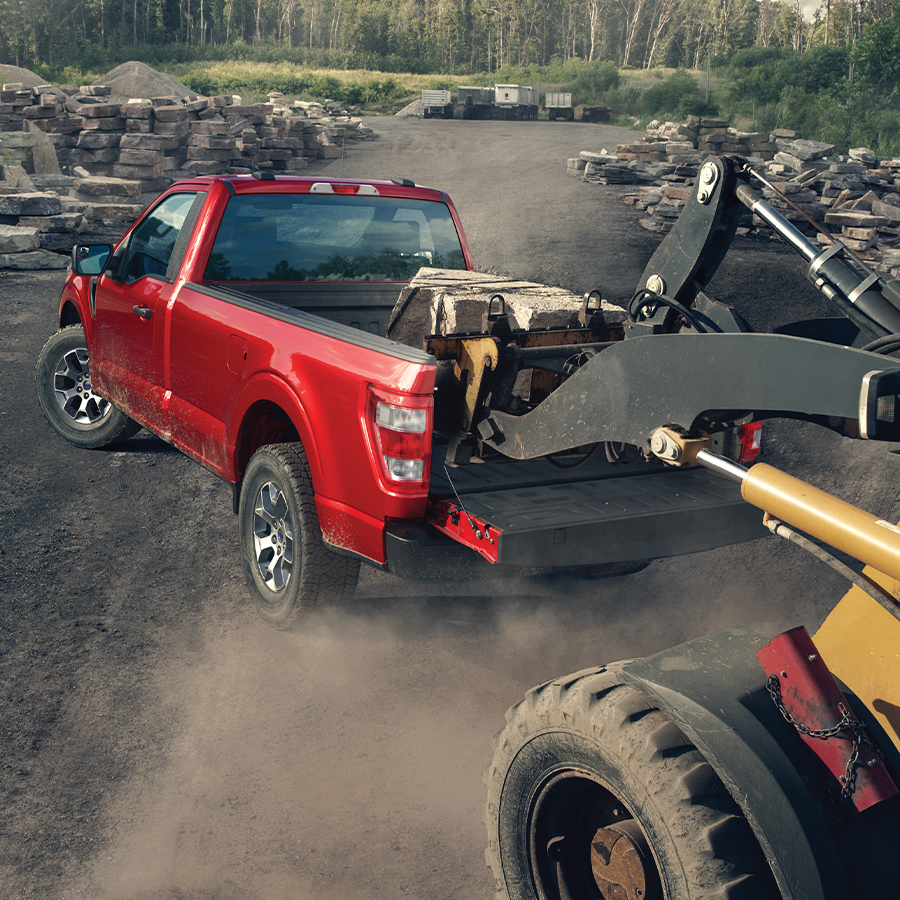 A 2024 Ford F-150® pickup in Iconic Silver parked at a quarry having paver bricks being loaded into the truck bed