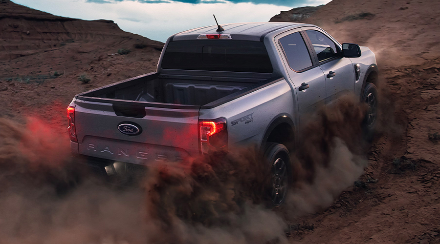 A 2024 Ford Ranger® being driven up a sandy dune.