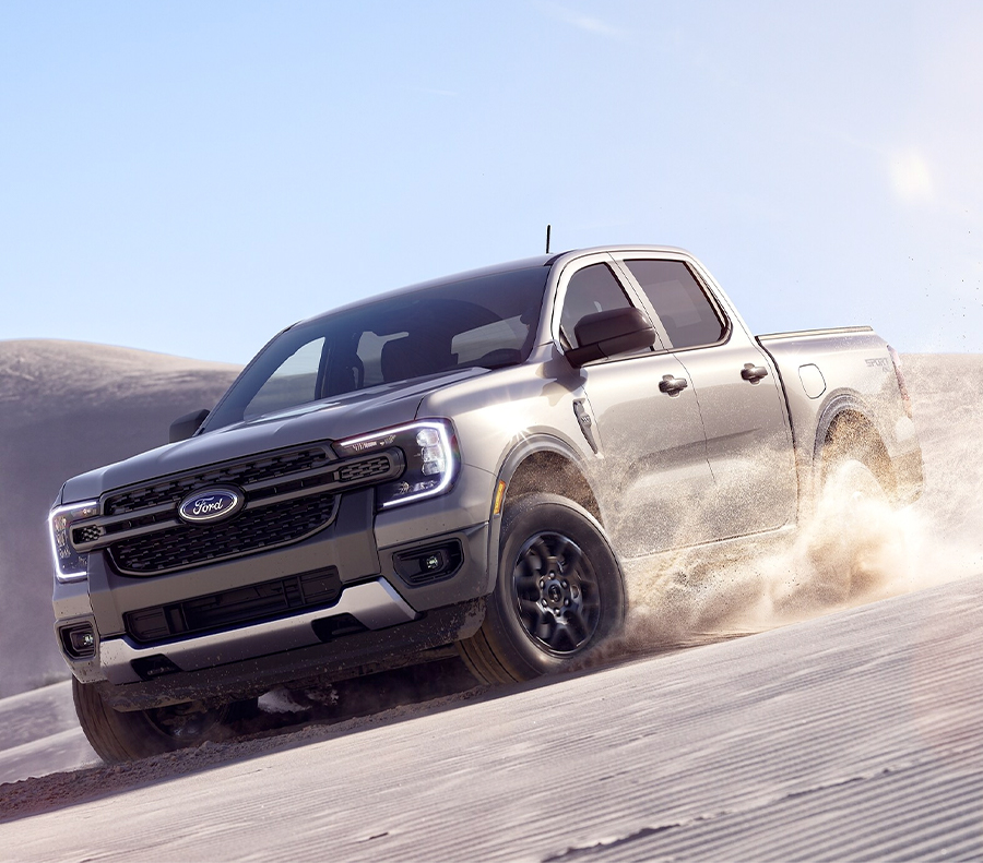 A 2024 Ford Ranger® XLT in Iconic Silver is being driven on a desert dune.
