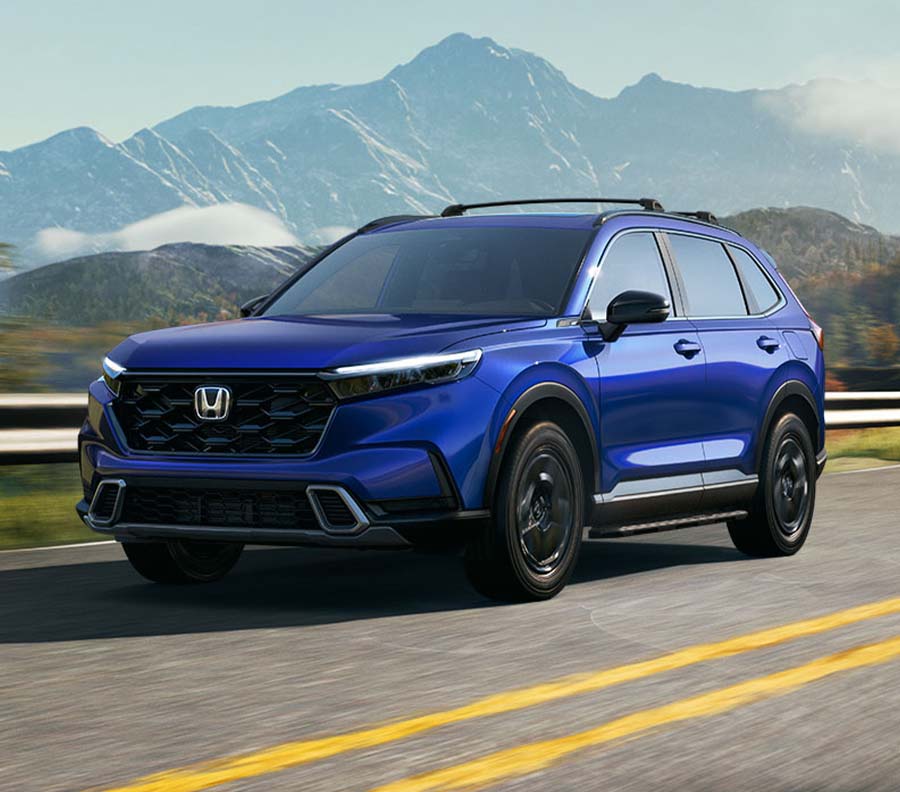 Front 3/4 shot of Blue 2024 Honda CR-V  driving down road overlooking mountains.