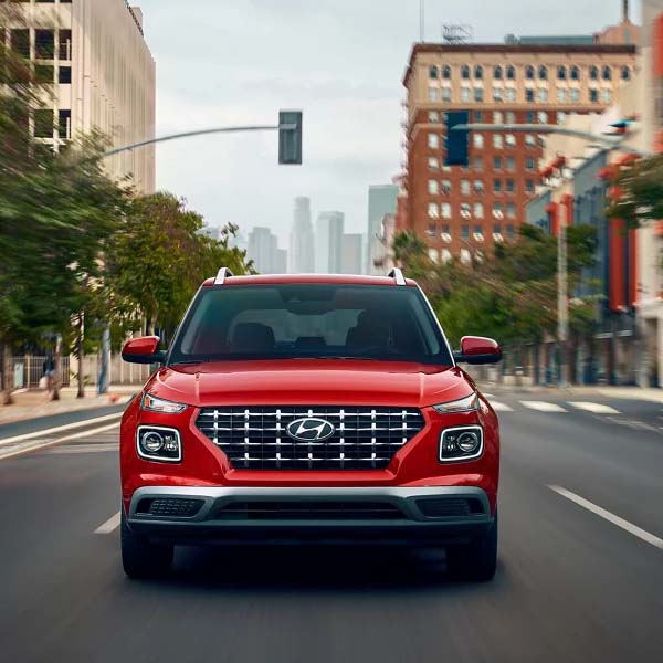 Action shot of the 2025 Hyundai Venue driving through a city