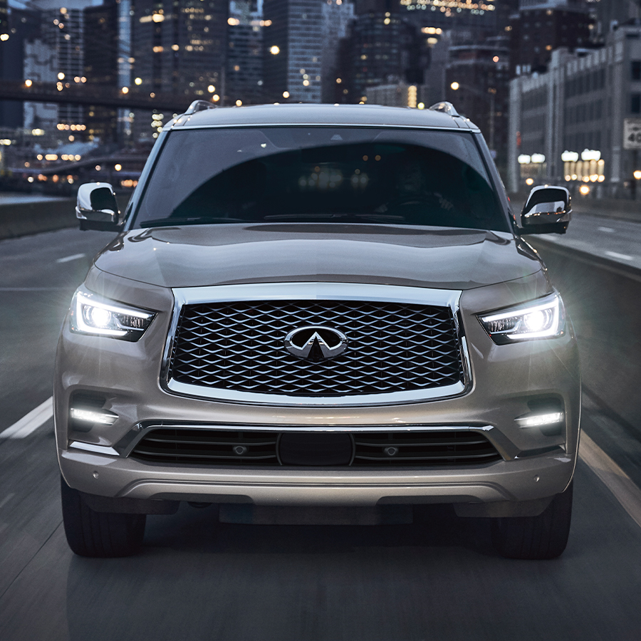 Front view of 2024 INFINITI QX80 SUV driving down city street