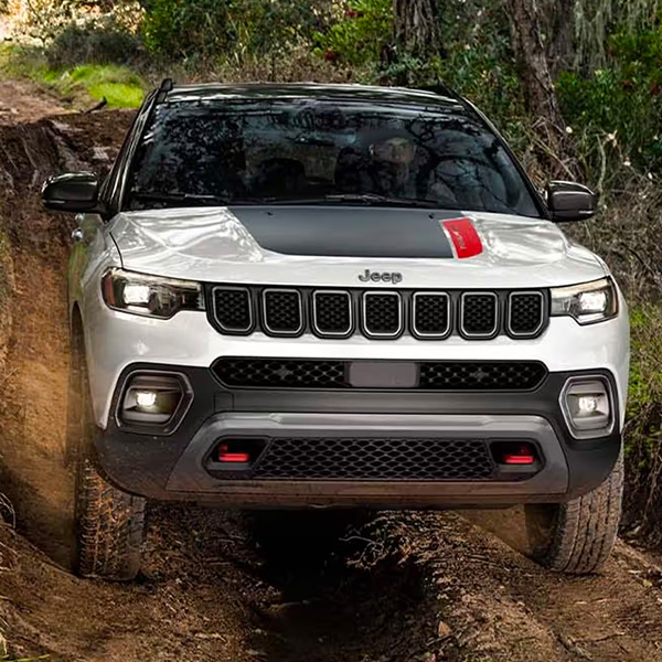 Exterior shot of 2024 Jeep Compass driving through mud