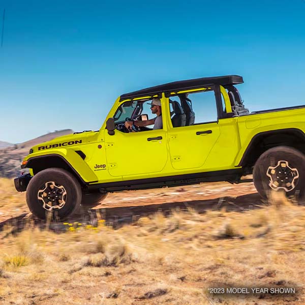 2023 Jeep Gladiator Rubicon shown with half doors driving offroad