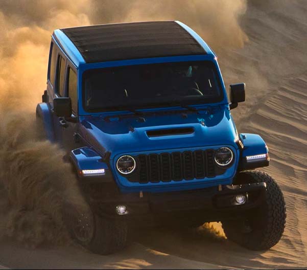 2024 Jeep Wrangler driving off-road in the desert.