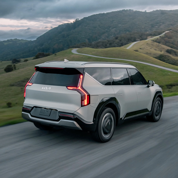 2024 Kia EV9 in white, three-quarter back view, driving on road