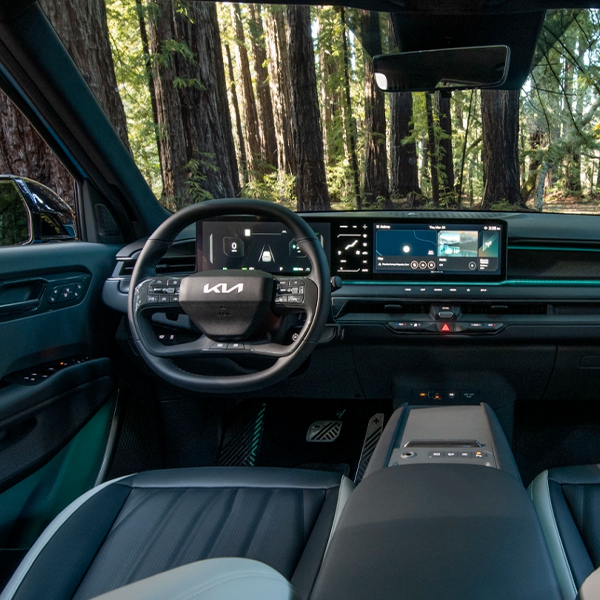 2024 Kia EV9 interior, driver seat and passenger seat view, featuring black SynTex seats and a spacious interior