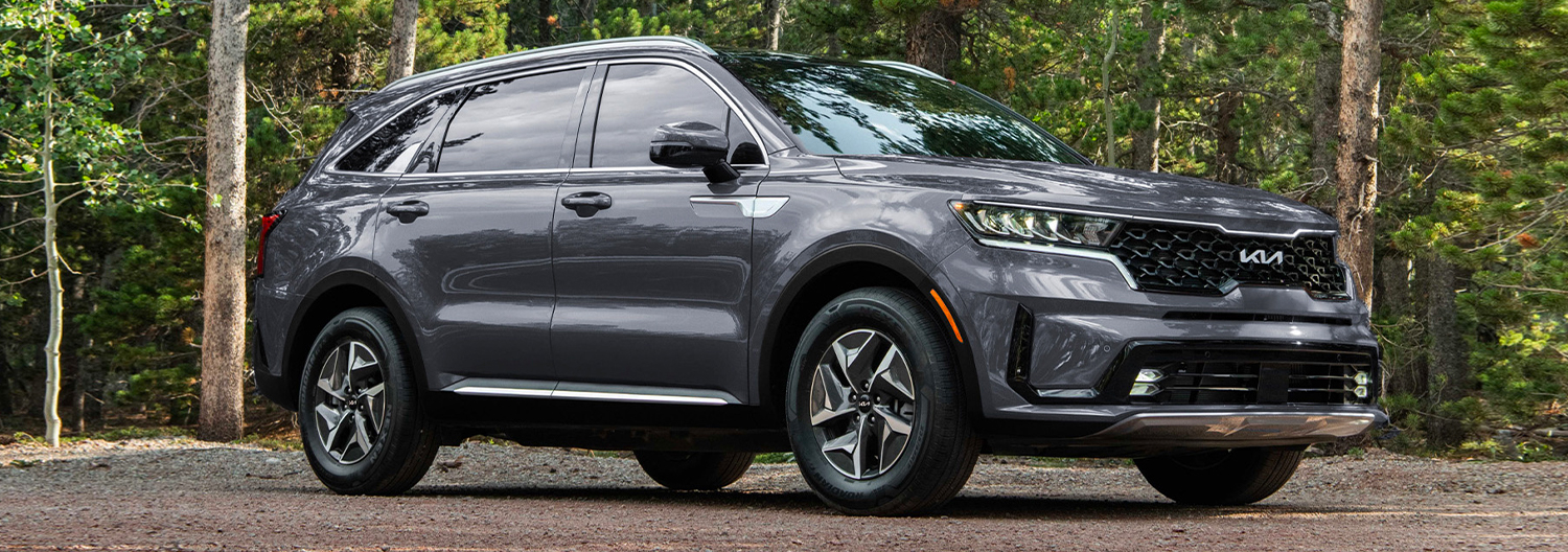 Front 3/4 shot of the 2024 Kia Soreno parked in front of woods
