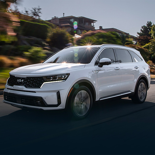 New Kia Sorento driving through a scenic neighborhood