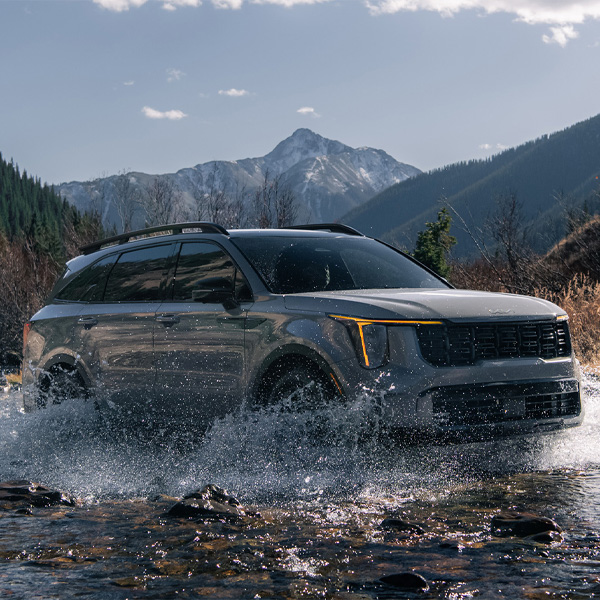 2024 Kia Sorento, three-quarter front view, driving through a river of water in the mountains