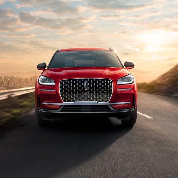 A 2024 Lincoln Corsair® SUV is being driven on a sun-drenched road