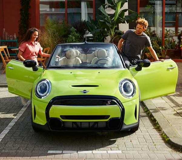 A front view of the 2022 MINI Convertible parked in front of a building.