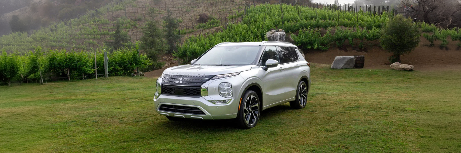 Angled view of a silver 2024 Mitsubishi Outlander SUV parked