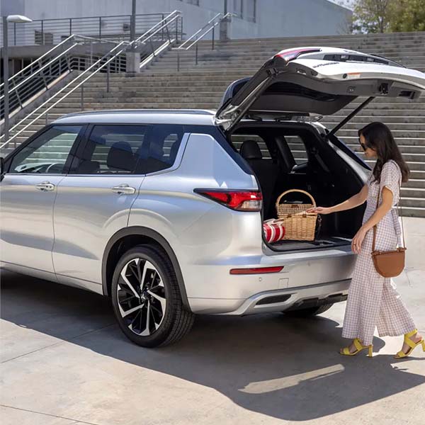 Woman retrieving a basket out of the trunk of a 2024 Mitsubishi Outlander