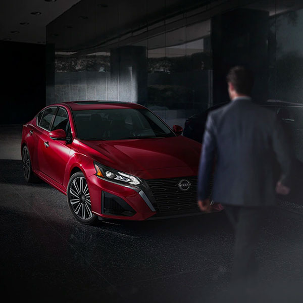 Man in suit walking past 2024 Nissan Altima parked