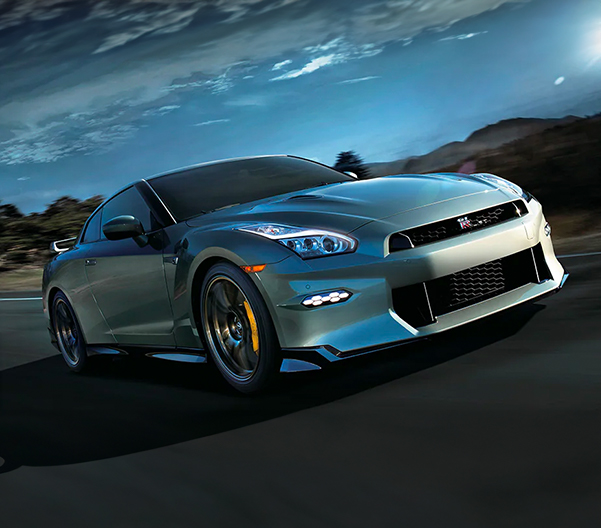 2024 Nissan GT-R® in Millennium Jade driving down a road at speed, front view.