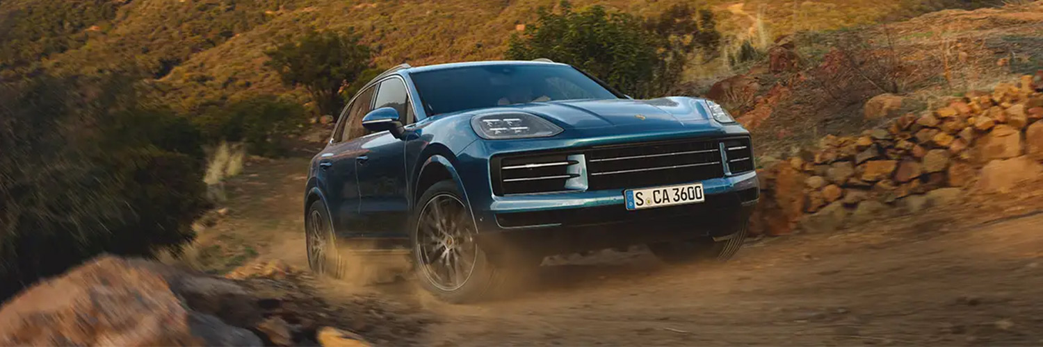 Porsche Cayenne driving up dirt road