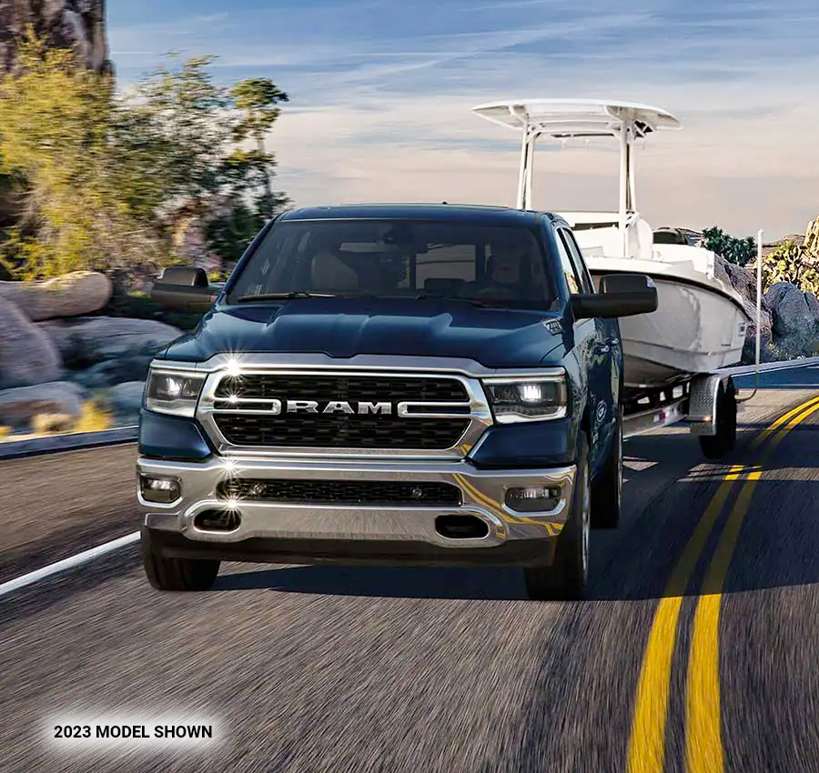 The 2023 Ram 1500 towing a boat.