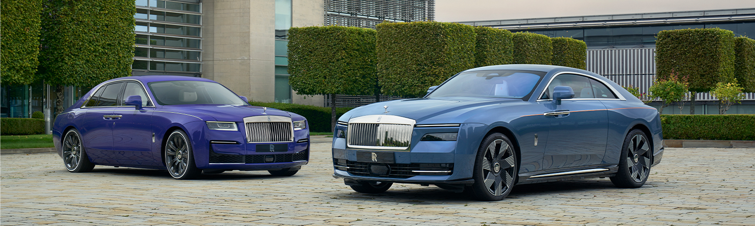 2 Rolls Royce parked in front of building