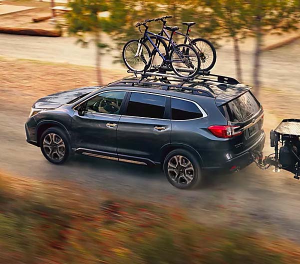 2024 Subaru Ascent Touring shown in Magnetite Gray Metallic with accessory equipment driving on a dirt road