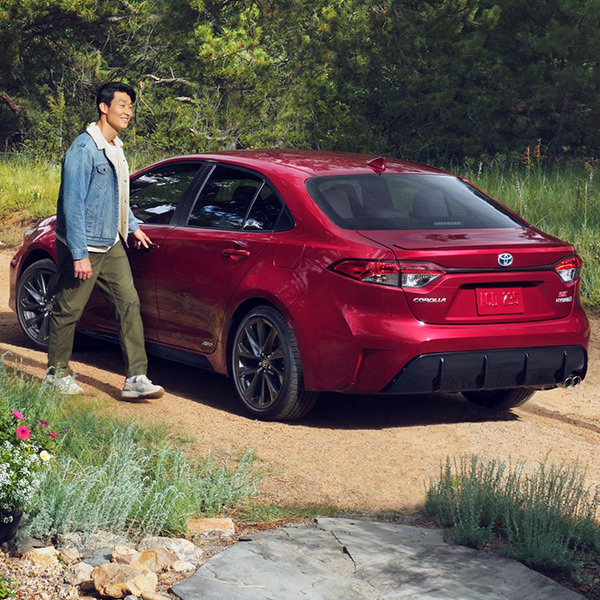 Rear view of 2024 Toyota Corolla Hybrid with man opening door