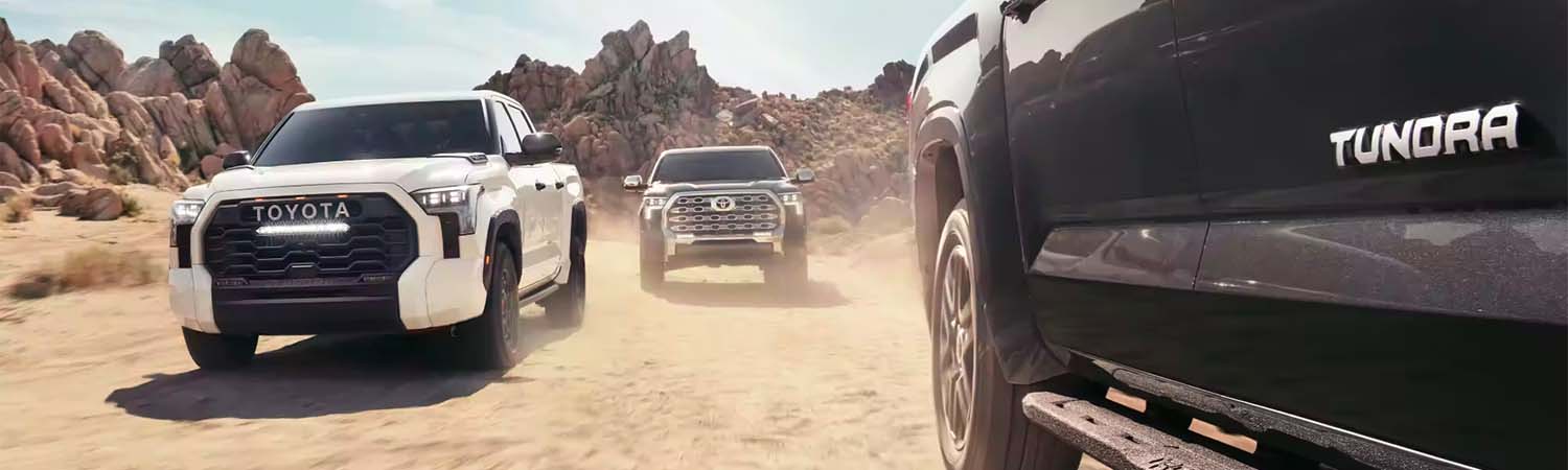 Front view of 2024 Toyota Tundra's driving on a dirt road
