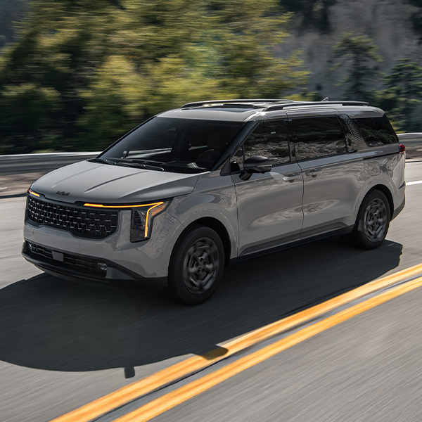 Kia Carnival driivng down road