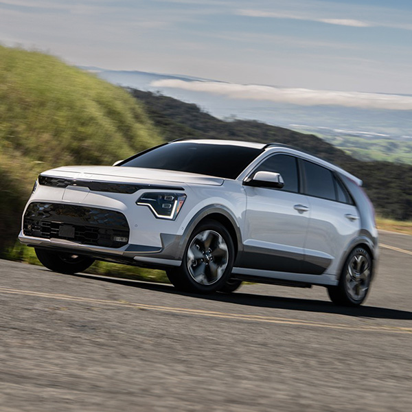 2025 Kia Niro EV driving upwards on a steep hill, front three-quarter view.