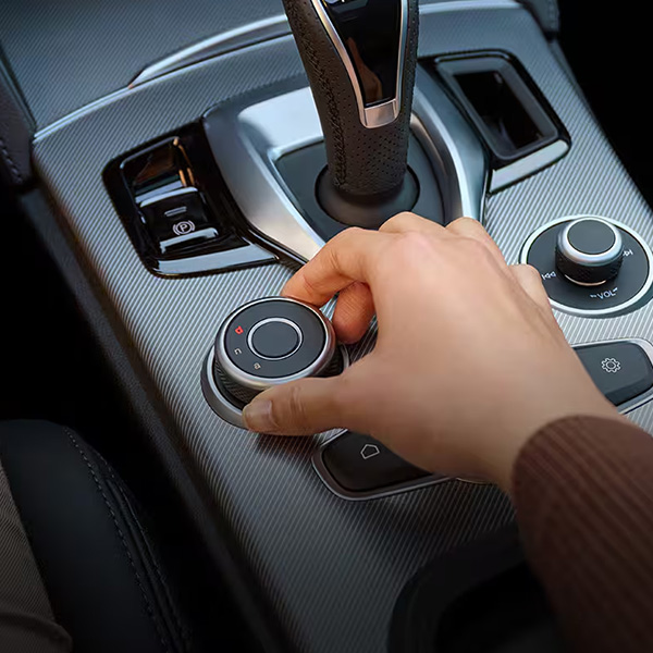 Close-up of a hand using the rotary infotainment controller on the center console of an Alfa Romeo Stelvio.