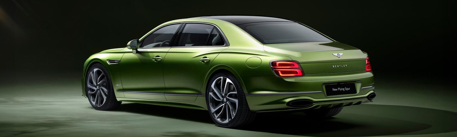 Rear of green Bentley Flying Spur parked in studio setting.