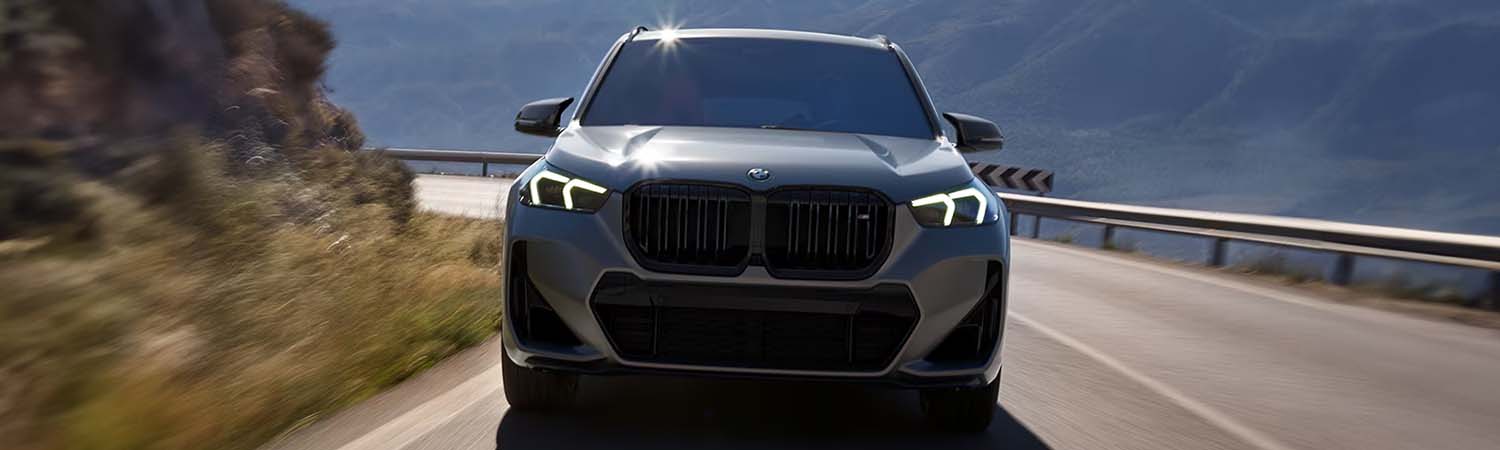 Grey 2025 BMW X1 driving on mountain highway