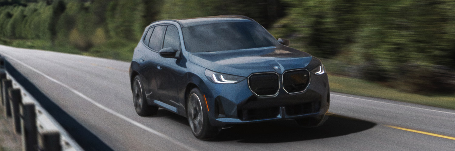 Front 3/4 shot of the 2025 BMW X3 driving down road