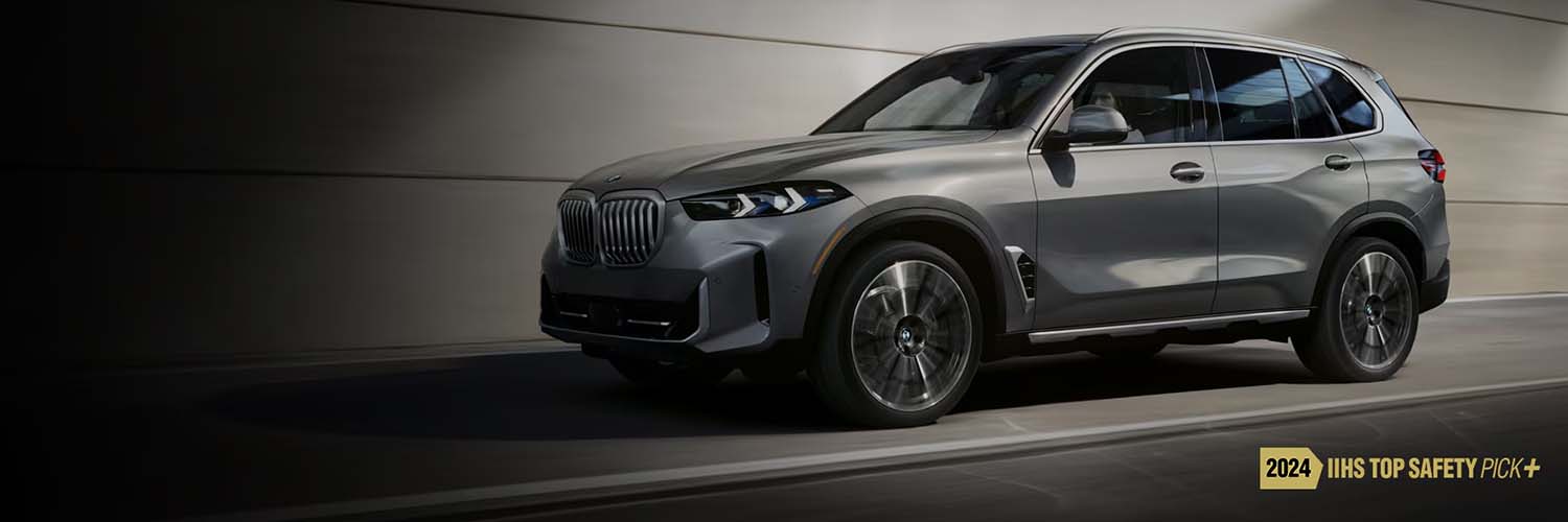 Action shot of the 2025 BMW X5 driving down a highway with the 2024 IIHS Top Safety Pick logo included on the image
