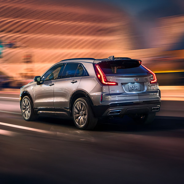 Rear View of the 2025 Cadillac XT4 Driving Fast Through the City at Night