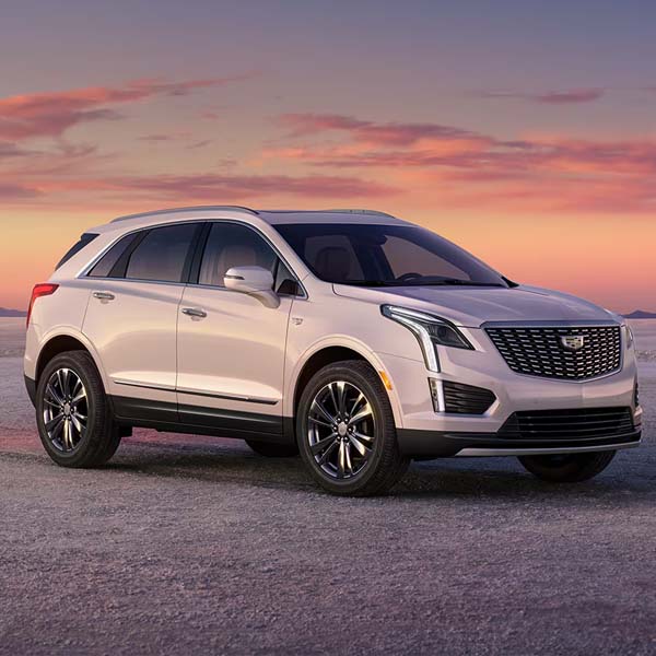 White 2025 Cadillac XT5 parked in desert at sunset.