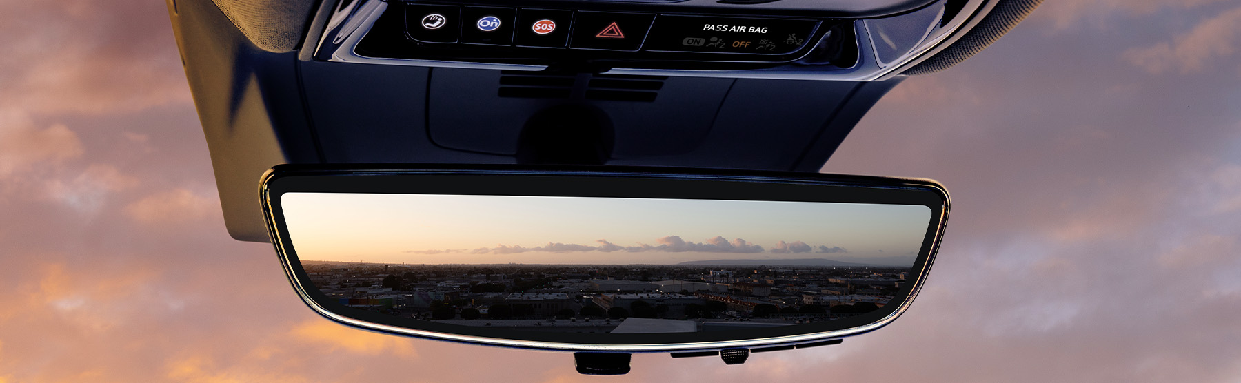 2025 Cadillac Optiq, Sport 2 (6MR26), interior detail, close up, NOIR (EGW), rear view mirror, OnStar button, safety controls, city scape in mirror, sunset through windshield.