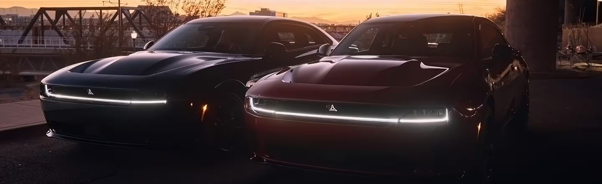 Dodge Chargers pictured next to each other in a parking lot at sunset