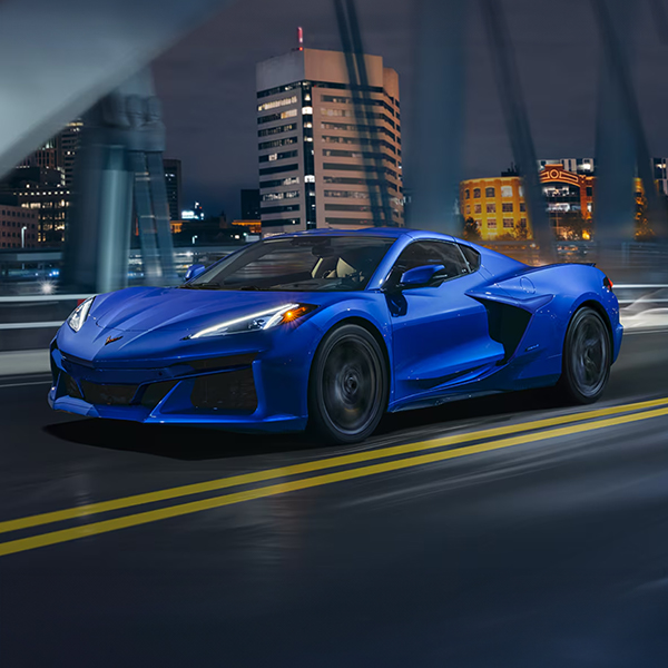 Front 3/4 shot of the 2025 Chevrolet Corvette E-Ray driving down bridge