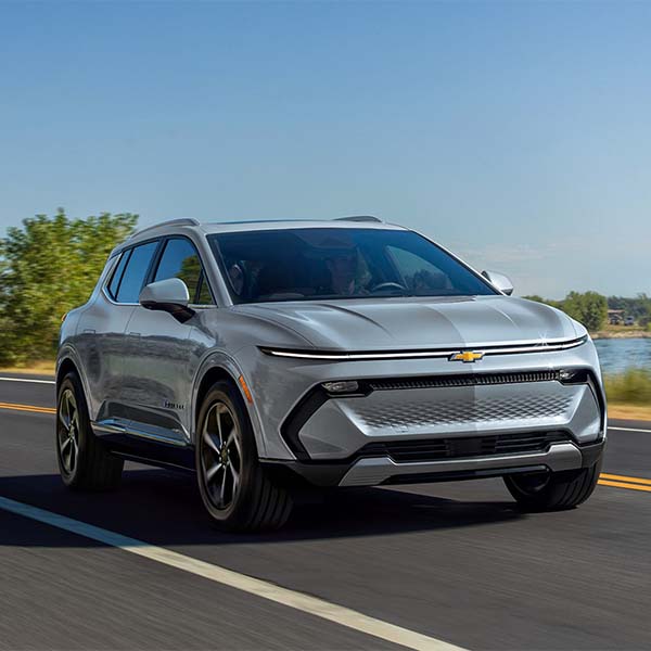 Silver 2025 Chevrolet Equinox racing down a waterfront street