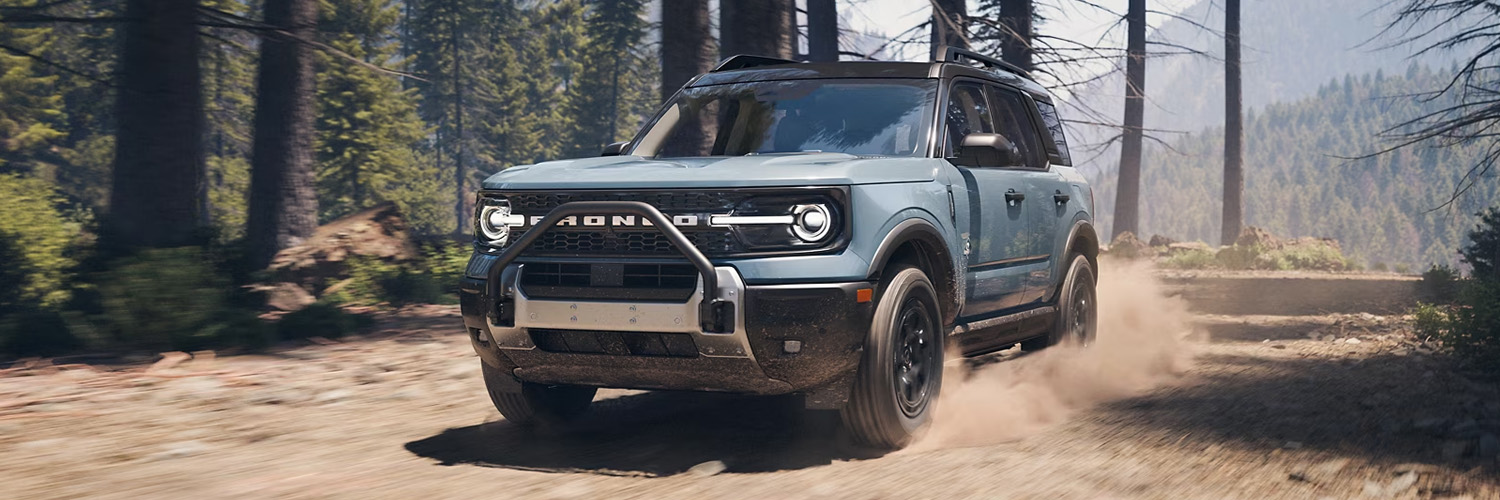 2025 Ford Bronco Sportˆ being driven on a dirt path with trees on either side