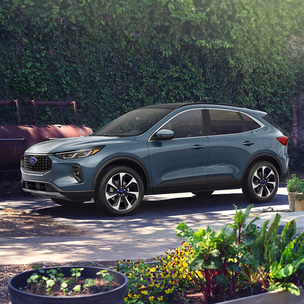 2025 Ford Escape® SUV in Vapor Blue Metallic parked near a person gardening