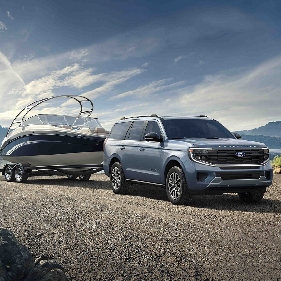 2025 Ford Expedition® model with a driver towing a boat on a trailer
