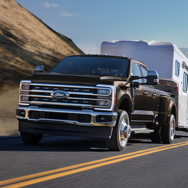 2025 Ford Super Duty® F-350® towing a trailer up a road