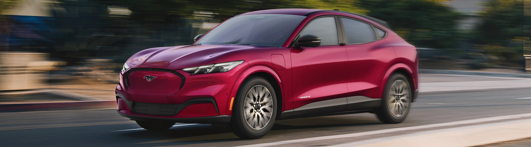 3/4 side view of the Ford Mustang Mach-E parked outside a building