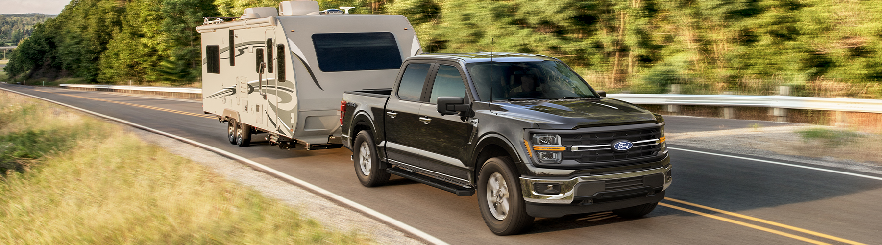 2025 F-150 Black Towing RV on rural highway