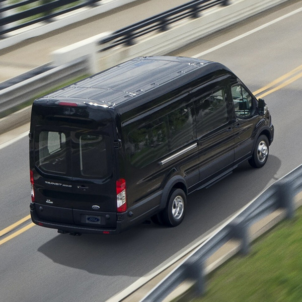 Overhead rear 3/4 shot of the 2025 Ford Transit driving over bridge