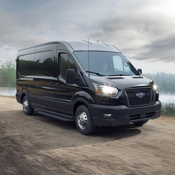 Front 3/4 shot of the 2025 Ford Transit driving down dirt road