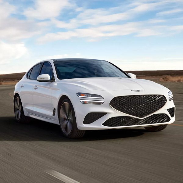 White 2025 Genesis G70 driving on desert highway