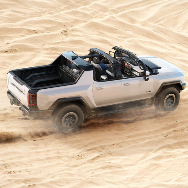 Aerial view of 2025 GMC HUMMER EV Pickup driving through desert.